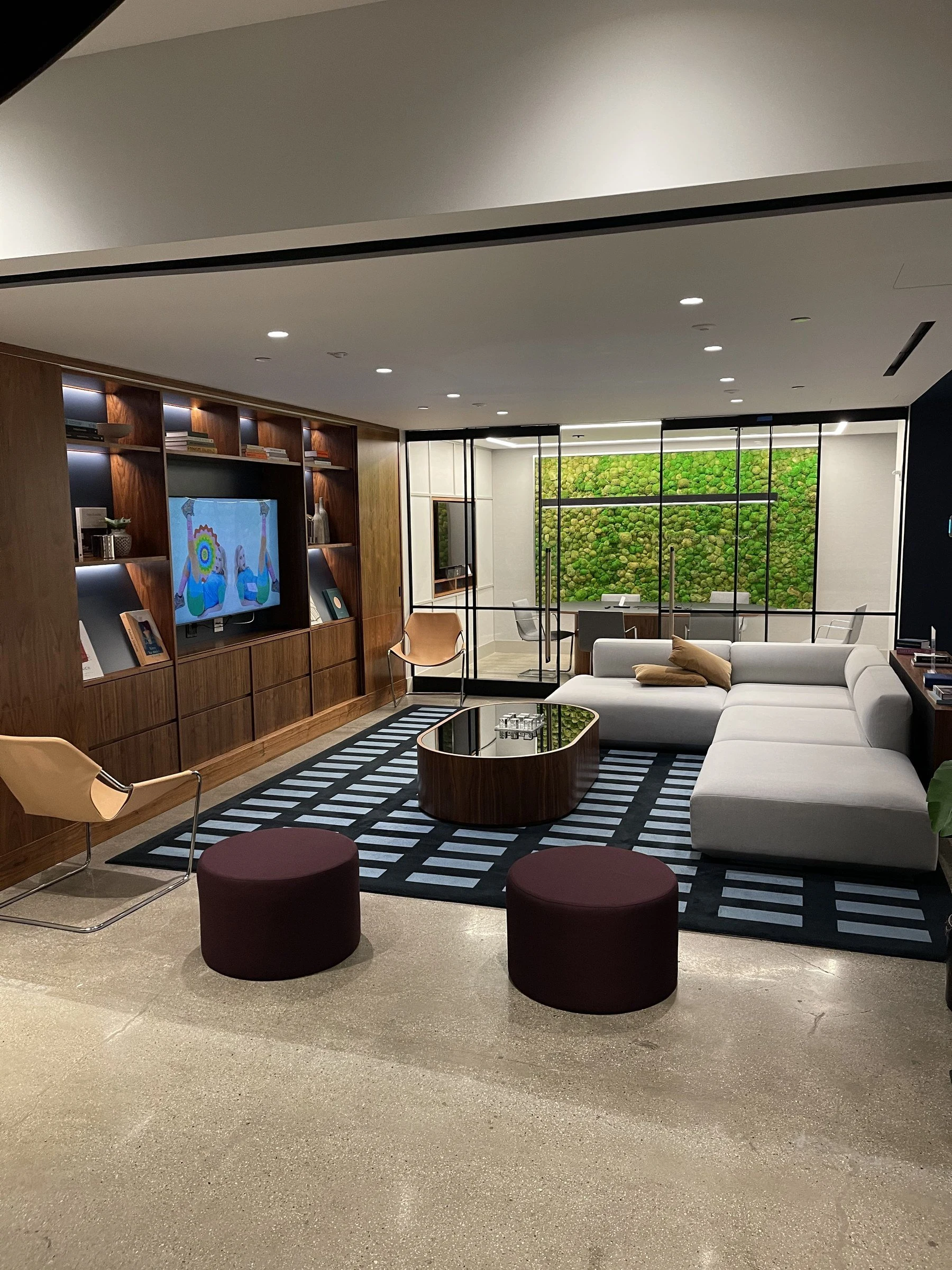 Seating, walnut joinery and a living wall in an amenity lounge cared for by Luxor